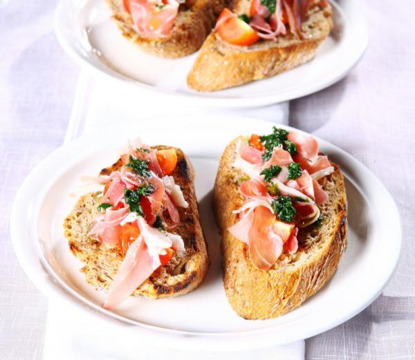 Bruschetta s bazalkovým pestom, cherry paradajkami a prosciuttom Bruschetta s bazalkovým pestom, cherry paradajkami a prosciuttom